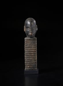 Lobi - Burkina Faso/Costa d'Avorio - Scultura con testa antropomorfa su colonna lavorata e incisa geometricamente.Legno a patina nera e pigmenti.