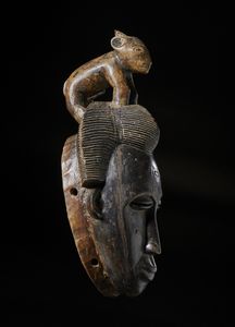 Guro - Costa d'Avorio : Maschera antropomorfa con figura zoomorfa. Legno duro a patina scura e pigmenti.  - Asta Asta 422 | AFRICA, OCEANIA E AMERICHE - ARTIGIANATO AFRICANO: VARI COMMITTENTI E SELEZIONE DALLA COLLEZIONE BARTOLOMUCCI Online - Associazione Nazionale - Case d'Asta italiane