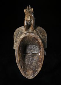 Guro - Costa d'Avorio : Maschera antropomorfa con figura zoomorfa. Legno duro a patina scura e pigmenti.  - Asta Asta 422 | AFRICA, OCEANIA E AMERICHE - ARTIGIANATO AFRICANO: VARI COMMITTENTI E SELEZIONE DALLA COLLEZIONE BARTOLOMUCCI Online - Associazione Nazionale - Case d'Asta italiane