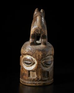 Yoruba -Nigeria : Maschera a casco Epa gianeiforme con figura zoomorfa scolpita sulla sommit. Legno duro a patina marrone e pigmenti.  - Asta Asta 422 | AFRICA, OCEANIA E AMERICHE - ARTIGIANATO AFRICANO: VARI COMMITTENTI E SELEZIONE DALLA COLLEZIONE BARTOLOMUCCI Online - Associazione Nazionale - Case d'Asta italiane