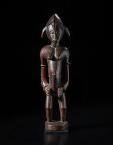 Senufo - Costa d'Avorio/Mali/Burkina Faso - Grande scultura antropomorfa femminile. Legno duro a patina bruno-rossastra e tracce di caolino.