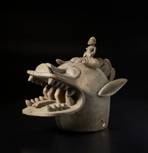 Senufo - Costa d'Avorio/Mali - Maschera zoomorfa 'sputafuoco' con piccola figura antropomorfa e di camaleonte sulla fronte.Legno duro a patina naturale.