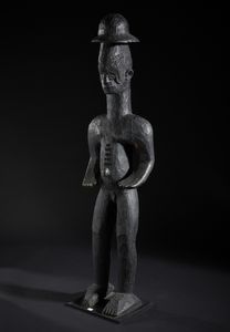 Igbo - Nigeria : Grande scultura antropomorfa con cappello. Legno duro a patina nera.  - Asta Asta 422 | AFRICA, OCEANIA E AMERICHE - ARTIGIANATO AFRICANO: VARI COMMITTENTI E SELEZIONE DALLA COLLEZIONE BARTOLOMUCCI Online - Associazione Nazionale - Case d'Asta italiane