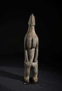 Mossi - Burkina Faso - Grande scultura antropomorfa stilizzata. Legno duro a patina bruno-grigiastra.