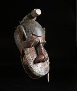 Baule - Costa d'Avorio - Maschera zoomorfa con figura antropomorfa.Legno, pigmenti e metallo.