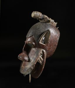 Baule - Costa d'Avorio : Maschera zoomorfa con figura antropomorfa.Legno, pigmenti e metallo.  - Asta Asta 422 | AFRICA, OCEANIA E AMERICHE - ARTIGIANATO AFRICANO: VARI COMMITTENTI E SELEZIONE DALLA COLLEZIONE BARTOLOMUCCI Online - Associazione Nazionale - Case d'Asta italiane