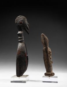 Dogon - Mali : Lotto composto da una puleggia da telaio con testa antropomorfa e da una piccola scultura antropomorfa stilizzata o Nommo, antenato primordiale, in piedi con le braccia alzate. Legno.  - Asta Asta 422 | AFRICA, OCEANIA E AMERICHE - ARTIGIANATO AFRICANO: VARI COMMITTENTI E SELEZIONE DALLA COLLEZIONE BARTOLOMUCCI Online - Associazione Nazionale - Case d'Asta italiane