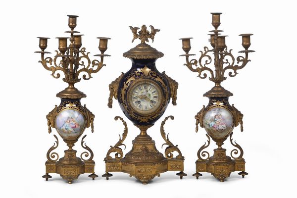 Trittico da camino composto da coppia di candelabri e un orologio in porcellana di Sevres e bronzo dorato. Francia XIX secolo  - Asta Pendole e orologi - Associazione Nazionale - Case d'Asta italiane