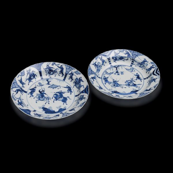 Coppia di piatti fondi in porcellana bianca e blu a decoro di battaglia, Cina, Dinastia Qing, epoca Kangxi (1662-1722)<BR>  - Asta Fine Chinese Works of Art - Associazione Nazionale - Case d'Asta italiane