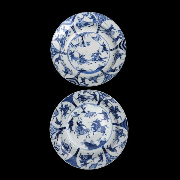 Coppia di piatti fondi in porcellana bianca e blu a decoro di battaglia, Cina, Dinastia Qing, epoca Kangxi (1662-1722)<BR>  - Asta Fine Chinese Works of Art - Associazione Nazionale - Case d'Asta italiane