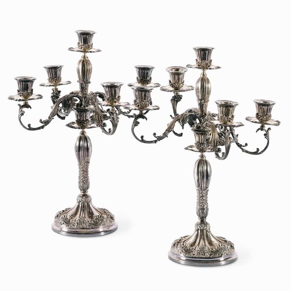 Coppia di candelabri in argento fuso, sbalzato e cesellato. Argenteria italiana del XX secolo (apparentemente privi di punzonatura)  - Asta L'Art de la Table - Associazione Nazionale - Case d'Asta italiane