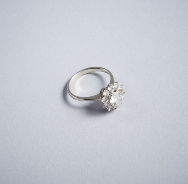 . : Anello solitario con contorno di diamanti bianchi taglio a brillante. Diamante centrale 1,30 ct. ca.Diamanti llaterali 0,60 ct. ca.  - Asta GIOIELLI - OROLOGI - ALL I WANT FOR CHRISTMAS Online - Associazione Nazionale - Case d'Asta italiane