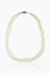 COLLANA - Lunghezza cm 62 composta da due fili di perle giapponesi del diam. di mm 7 5. Chiusura in oro bianco con smeraldo  [..]