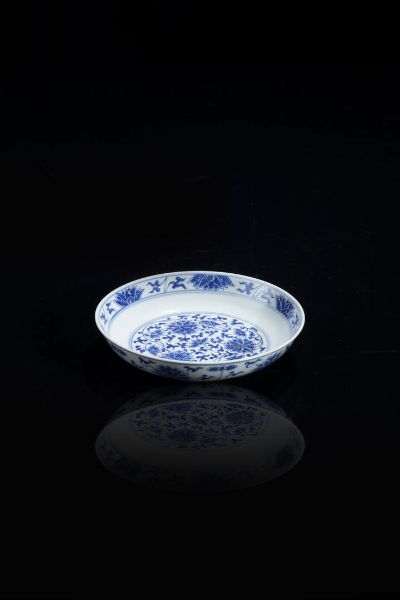 PIATTO : Piatto in porcellana bianca e blu con decori floreali  Cina  dinastia Qing XIX sec  epoca Guangxu (1875-1908) H cm 3 5  Diam cm 16  - Asta Arte orientale - Associazione Nazionale - Case d'Asta italiane