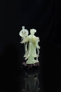 GUANYIN - Guanyin in giadeite raffigurante donna con attrezzi e fiori  poggiante su base in legno  Cina  Repubblica  XX  [..]