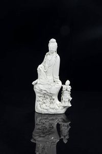 GUANYIN - Guanyin seduta in porcellana blanc de chine con figura di ragazzo  Cina  Repubblica  XX sec H cm 32x16