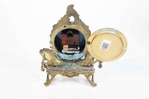 Piccolo orologio da tavolo in metallo dorato. XX secolo  - Asta Antiquariato - Associazione Nazionale - Case d'Asta italiane