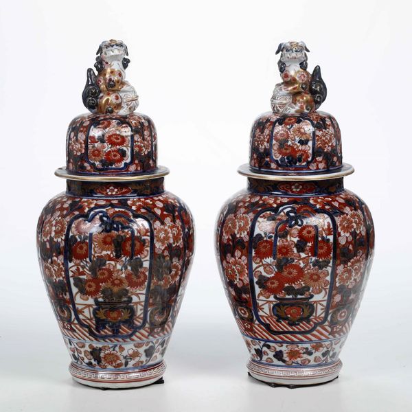 Coppia di potiche in porcellana Imari con decori floreali entro riserve e prese a foggia di cane di Pho, Cina, Dinastia Qiing, XIX secolo  - Asta Arte orientale  - Associazione Nazionale - Case d'Asta italiane