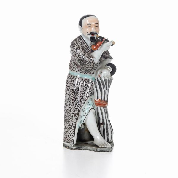 Figura in porcellana di personaggio maschile con pipa, Cina, Dinastia Qing, XIX secolo  - Asta Arte orientale  - Associazione Nazionale - Case d'Asta italiane