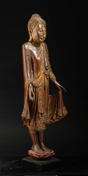 Figura di Buddha stante su fiore di loto in legno parzialmente laccato e dorato, Thailandia, XIX secolo  - Asta Arte orientale  - Associazione Nazionale - Case d'Asta italiane