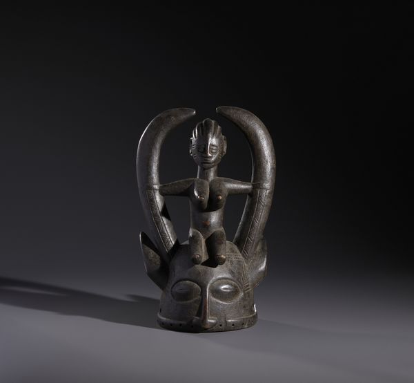 Senufo - Costa d'Avorio/Mali/Burkina Faso : Nello stile di Maschera a casco con personaggio antropomorfo seduto in legno duro a patina nera  - Asta Asta 444 | AFRICA, OCEANIA E AMERICHE - ARTIGIANATO AFRICANO: VARI COMMITTENTI E SELEZIONE DALLA COLLEZIONE BARTOLOMUCCI Online - Associazione Nazionale - Case d'Asta italiane