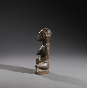 Kongo - Repubblica Democratica del Congo : Nello stile di Scultura antropomorfa in forma di maternit Legno duro a patina scura, fibre e metallo  - Asta Asta 444 | AFRICA, OCEANIA E AMERICHE - ARTIGIANATO AFRICANO: VARI COMMITTENTI E SELEZIONE DALLA COLLEZIONE BARTOLOMUCCI Online - Associazione Nazionale - Case d'Asta italiane