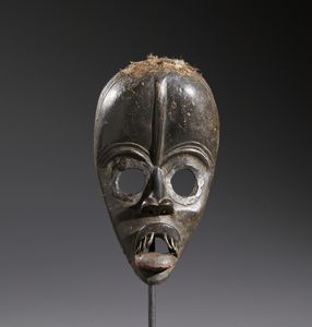 Dan - Costa d'Avorio/Liberia - Nello stile di Maschera antropomorfa  in legno duro a patina scura, tessuto, metallo e tracce di offerte sacrificali
