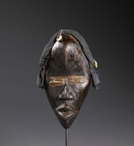 Dan - Costa d'Avorio/Liberia - Nello stile di Maschera antropomorfa in legno duro a patina scura, tessuto e conchiglie