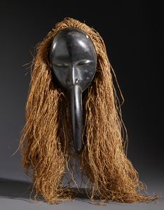 Dan - Costa d'Avorio/Liberia - Nello stile di Maschera antropomorfa con becco in legno duro a patina nera e raffia