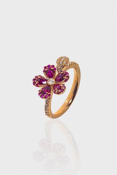 ANELLO : Peso gr 4 7 Misura 14 854) in oro rosa  sommit a fiore  con petali in rubini taglio ovale e rotondo per totali ct 0 89 ca e diamanti taglio brillante per totali ct 0 22 ca  probabile colore G-H  purezza IF-VVS  - Asta Gioielli - Associazione Nazionale - Case d'Asta italiane