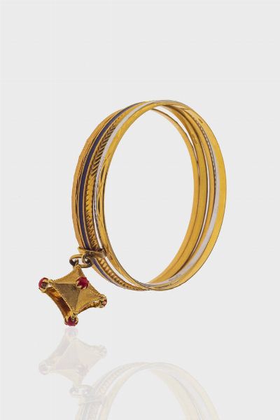 LOTTO DI CINQUE BRACCIALI : Peso complessivo gr 38 8 composto da: - tre bracciali rigidi in oro giallo  di cui due satinati e lavorati ed uno decorato con smalto blu; raccordati tra loro da ciondolo geometrico satinato con sfere di corallo rosso.  -due bracciali rigidi in oro giallo lavorato a motivi geometrici ed uno in oro bianco lavorato a segmenti specchiati  - Asta Gioielli - Associazione Nazionale - Case d'Asta italiane