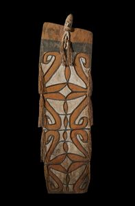 . - Scudo da guerra in legno inciso e dipinto arricchito da fibre vegetali, proveniente dalla cultura Asmat. Papua Nuova Guinea, XIX secolo.