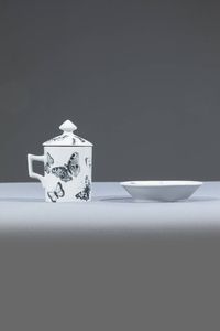 PIERO FORNASETTI Milano 1913 - 1988 - Tazza con coperchio e piattino in smalto. Anni '60 cm 16x14