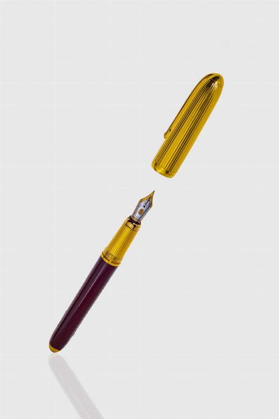 CARTIER : Penna stilografica  firmata Cartier  modello Diablo con cappuccio e finiture placcate oro giallo. Pennino in oro giallo e bianco. Corpo nei toni del bordeaux.  - Asta Gioielli  - Associazione Nazionale - Case d'Asta italiane