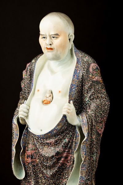 Rara figura di Saggio Famiglia Rosa stante in porcellana a smalti policromi con Buddha a rilievo nel centro del petto decorato per esteso con draghi tra le nuvole, Cina, Dinastia Qing, epoca Guangxu (1875-1908)  - Asta Fine Asian Works of Art - Associazione Nazionale - Case d'Asta italiane