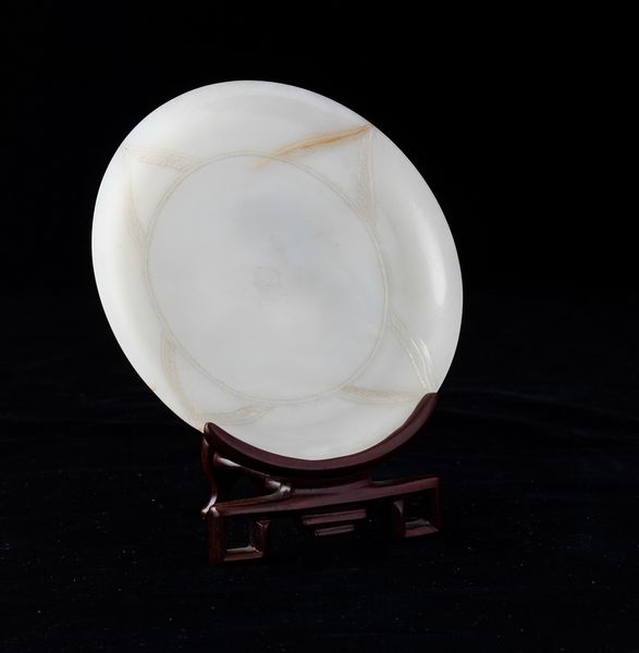 Piatto scolpito in giada bianca con decori simmetrici incisi, Cina, Dinastia Qing, XIX secolo  - Asta Fine Asian Works of Art - Associazione Nazionale - Case d'Asta italiane