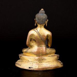 Figura di Buddha Sakyamuni seduto su doppio fiore di loto in bronzo dorato con tracce di policromia, ossidazione e dorature, Tibet, XVII secolo  - Asta Fine Asian Works of Art - Associazione Nazionale - Case d'Asta italiane