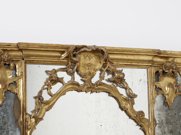 MANIFATTURA VENEZIANA DEL XVIII SECOLO : Imponente specchiera tripartita in legno intagliato e dorato, decorazioni a volute e motivi fitomorfi, cimasa centrata da stemma, specchi sui lati e alla base incisi a trofei  - Asta Asta 460 | ARTE ANTICA E DEL XIX SECOLO - Da una dimora veneta e altre committenze Tradizionale - Associazione Nazionale - Case d'Asta italiane