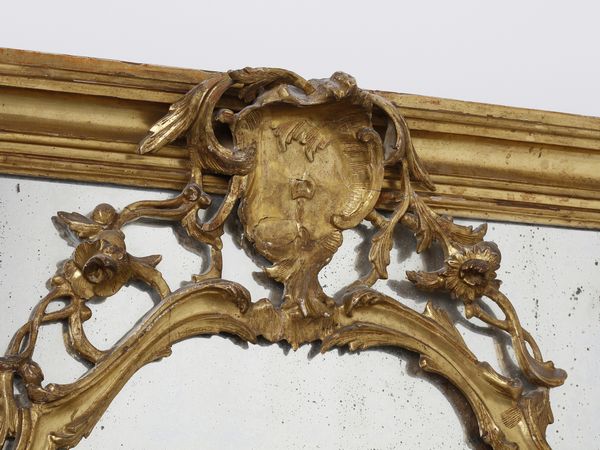 MANIFATTURA VENEZIANA DEL XVIII SECOLO : Imponente specchiera tripartita in legno intagliato e dorato, decorazioni a volute e motivi fitomorfi, cimasa centrata da stemma, specchi sui lati e alla base incisi a trofei  - Asta Asta 460 | ARTE ANTICA E DEL XIX SECOLO - Da una dimora veneta e altre committenze Tradizionale - Associazione Nazionale - Case d'Asta italiane