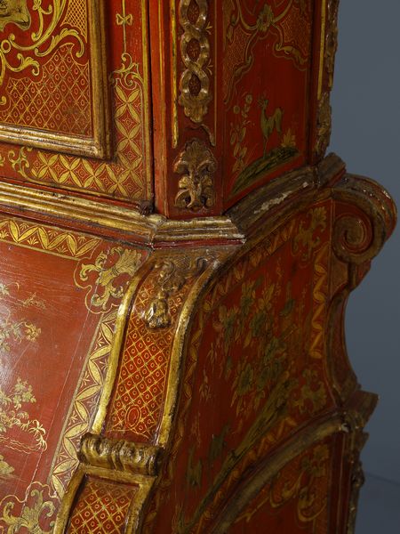 MANIFATTURA VENEZIANA DEL XVIII SECOLO : Eccezionale cassettone a ribalta con alzata, in legno laccato a fondo rosso e parzialmente dorato, fittamente decorato a motivi di ghirlande fiorite che racchiudono scene a 'chinoiseries' con magots, architetture e paesaggi orientali. alzata con cimasa di linea spezzata e due ante celanti sei vani con ornato floreale e una nicchia centrale, corpo inferiore di forma mossa con due cassetti sul fronte sormontati da anta calatoia con interni suddivisi in cassettini e vano centrale. fianchi concavi e lesene evidenziate da volute, piedi a mensola laccati a fondo verde scuro  - Asta Asta 460 | ARTE ANTICA E DEL XIX SECOLO - Da una dimora veneta e altre committenze Tradizionale - Associazione Nazionale - Case d'Asta italiane