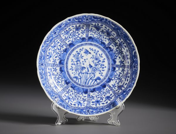 Arte Cinese : Piatto in porcellana bianca e blu dipinto al centro con uccelli tra rami di fiori.Cina, Dinastia Qing periodo Kangxi.  - Asta Asta 470 | ARTE ORIENTALE Online - Associazione Nazionale - Case d'Asta italiane