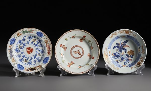 Arte Cinese : Gruppo di tre piatti in porcellana a decori Imari, due con raffigurazioni di pesci, uno dipinto con giardino fiorito.Cina, Dinastia Qing periodo Kangxi.  - Asta Asta 470 | ARTE ORIENTALE Online - Associazione Nazionale - Case d'Asta italiane