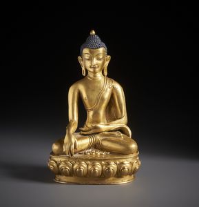 Arte Himalayana - Scultura in bronzo dorato raffigurante Buddha Sakyamuni elegantemente seduto su base a fiore di loto.Tibet / Nepal XVIII sec.