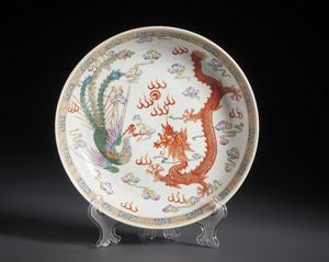 Arte Cinese : Piatto in porcellana a smalti policromi con decoro centrale di fenice e dragone tra nuvole fiammeggianti.Cina, Dinastia Qing fine XIX sec.  - Asta Asta 470 | ARTE ORIENTALE Online - Associazione Nazionale - Case d'Asta italiane