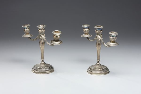 ARGENTIERE ITALIANO DEL XX SECOLO : Coppia di candelabri a tre fiamme in argento sbalzato e cesellato, fusto conico poggiante su piede circolare, decorato a motivi fitomorfi  - Asta Asta 472 | ARTE ANTICA E DEL XIX SECOLO Virtuale - Associazione Nazionale - Case d'Asta italiane