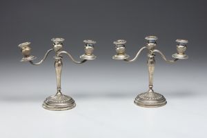 ARGENTIERE ITALIANO DEL XX SECOLO : Coppia di candelabri a tre fiamme in argento sbalzato e cesellato, fusto conico poggiante su piede circolare, decorato a motivi fitomorfi  - Asta Asta 472 | ARTE ANTICA E DEL XIX SECOLO Virtuale - Associazione Nazionale - Case d'Asta italiane