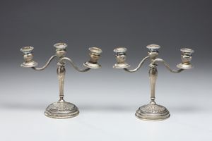 ARGENTIERE ITALIANO DEL XX SECOLO : Coppia di candelabri a tre fiamme in argento sbalzato e cesellato, fusto conico poggiante su piede circolare, decorato a motivi fitomorfi  - Asta Asta 472 | ARTE ANTICA E DEL XIX SECOLO Virtuale - Associazione Nazionale - Case d'Asta italiane