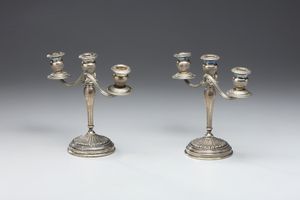 ARGENTIERE ITALIANO DEL XX SECOLO : Coppia di candelabri a tre fiamme in argento sbalzato e cesellato, fusto conico poggiante su piede circolare, decorato a motivi fitomorfi  - Asta Asta 472 | ARTE ANTICA E DEL XIX SECOLO Virtuale - Associazione Nazionale - Case d'Asta italiane