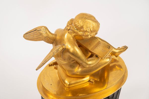 Pendola Impero con putto leggente in bronzo dorato e a patina scura, secolo XIX  - Asta Incanti d'Arte - Associazione Nazionale - Case d'Asta italiane