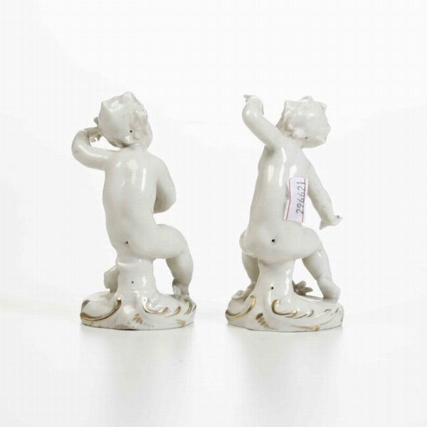 Coppia di figurine di putti, XX secolo.<BR>Porcellana. Marca: N con corona in blu.  - Asta Ceramiche - Associazione Nazionale - Case d'Asta italiane